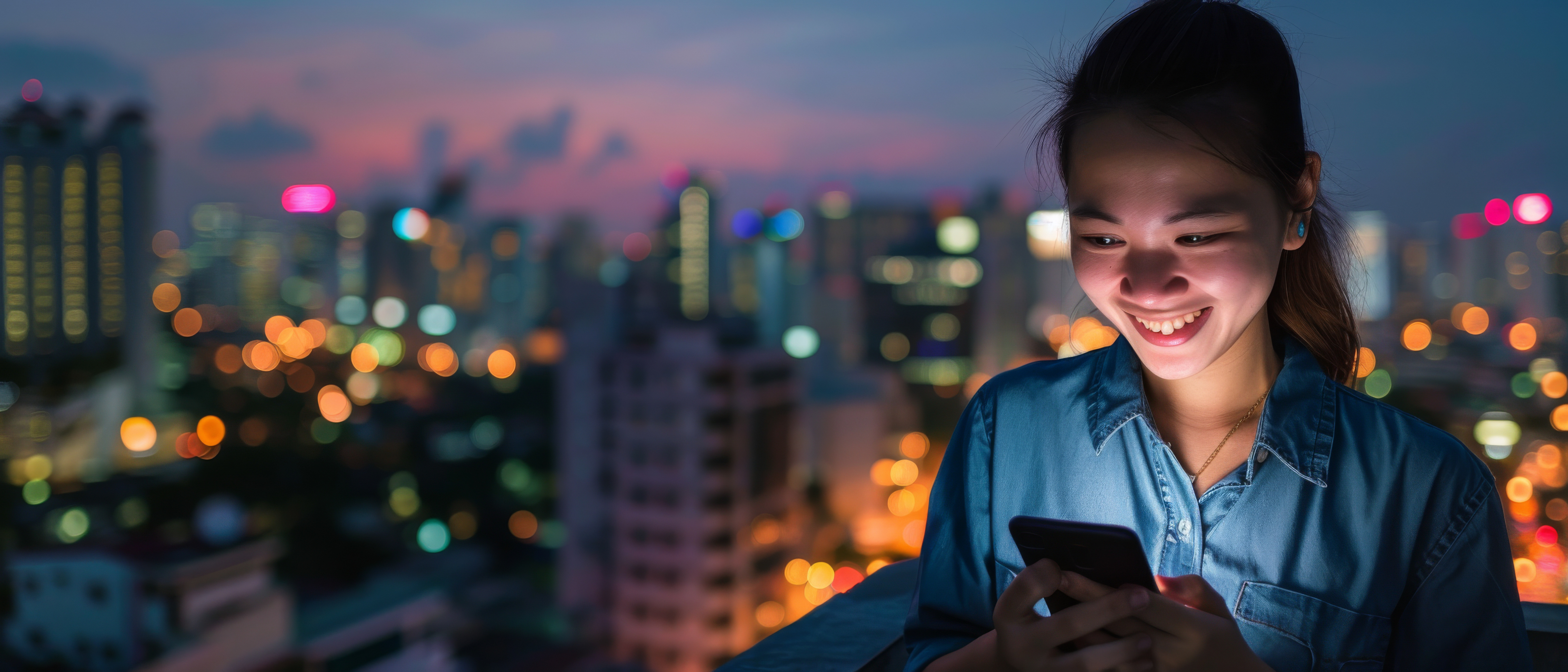 young-woman-denim-jacket-laughs-while-looking-her-smartphone-with-bustling-city-bokeh-lights-forming-beautiful-backdrop